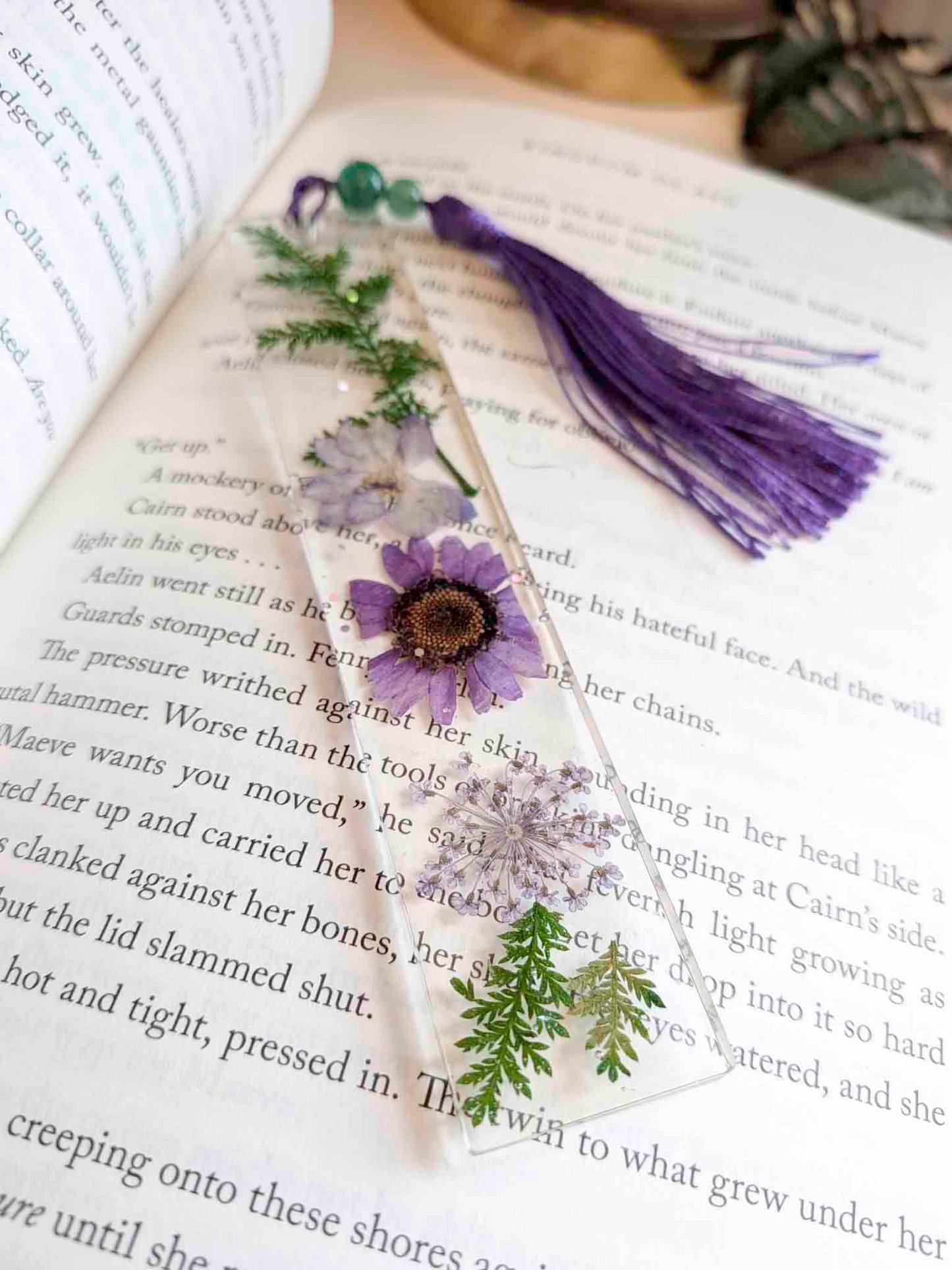 Decorative bookmark with flowers and a purple tassel on an open book