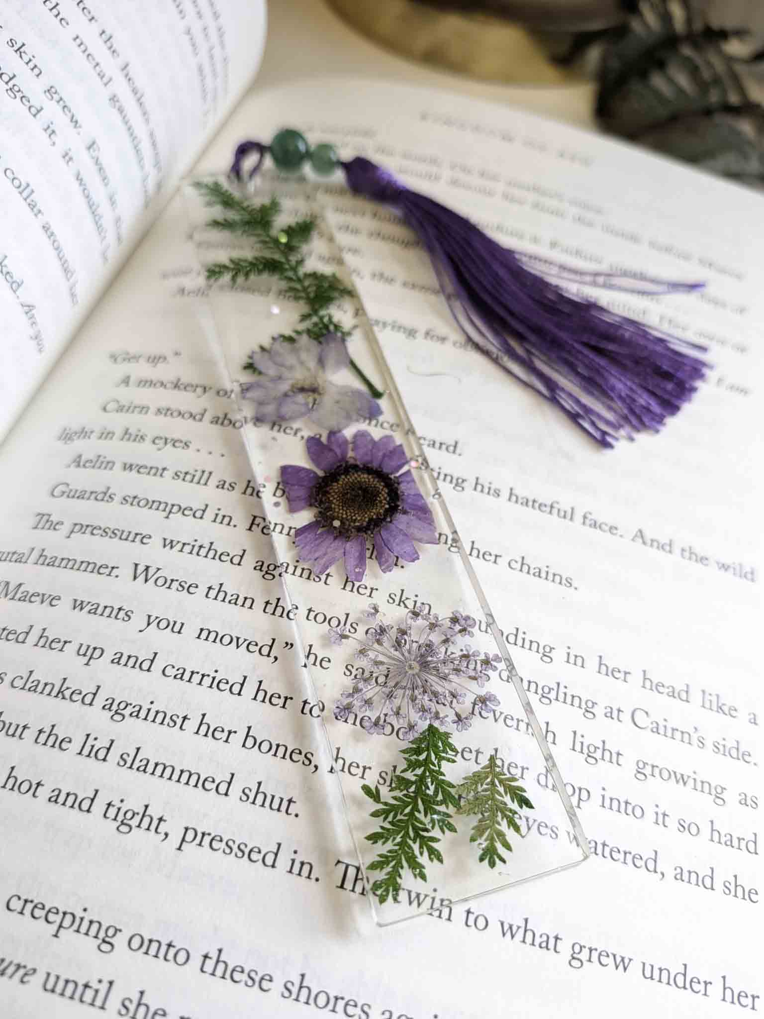 Decorative bookmark with flowers and a purple tassel on an open book
