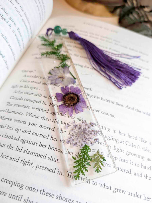 Decorative bookmark with flowers and a purple tassel on an open book