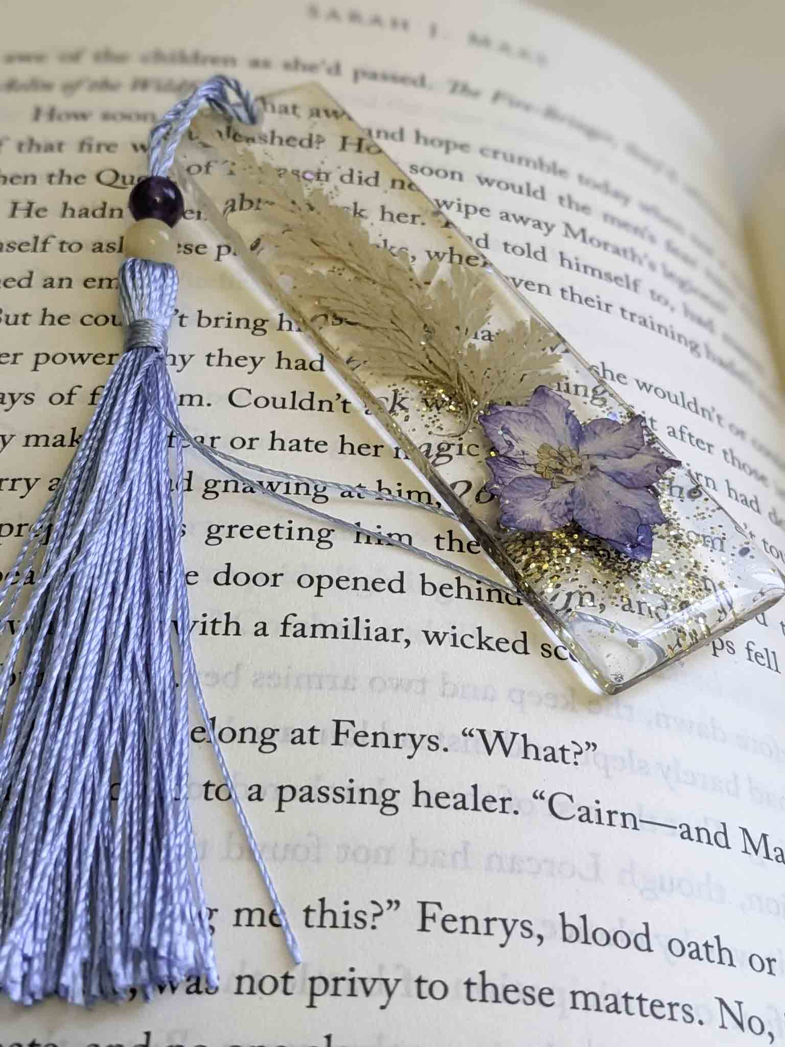 Decorative bookmark with tassel and pressed flower on an open book