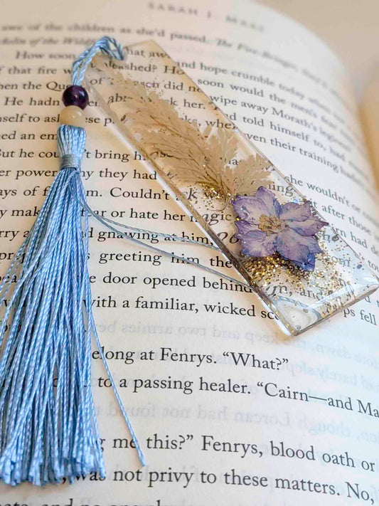 Decorative bookmark with tassel and pressed flower on an open book