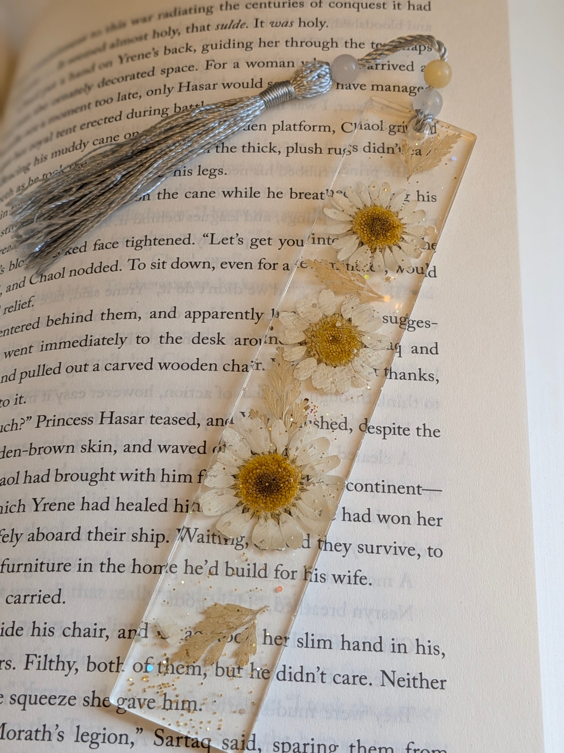 Decorative bookmark with pressed flowers on an open book