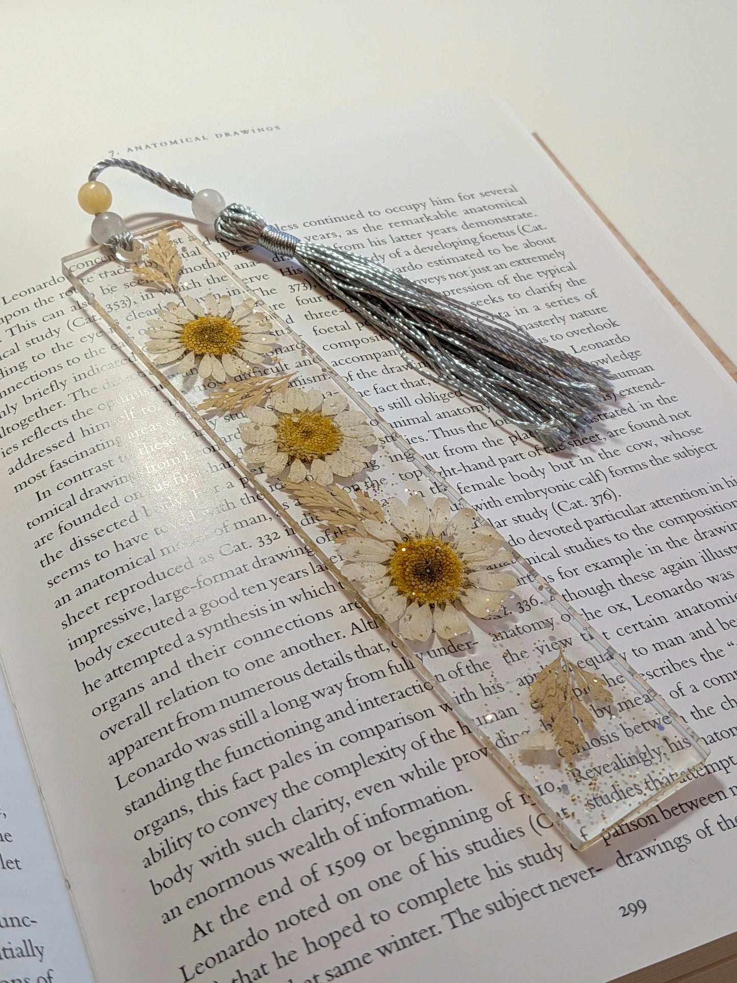 Bookmark with dried flowers and tassel on an open book
